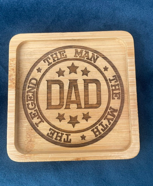 Wooden tray with engraved 'DAD' text on a blue background