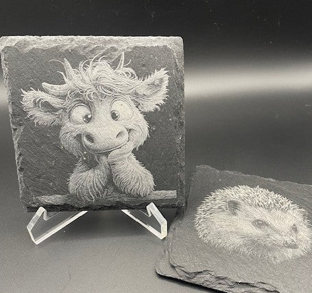 Sculpted stone with a character design on a stand, next to another stone with a hedgehog design.