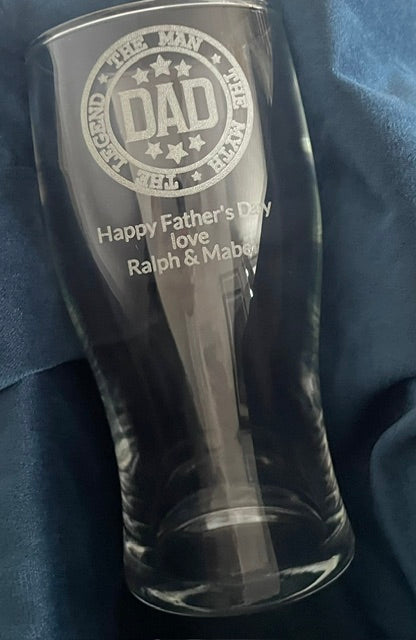 Clear glass engraved with 'DAD' and 'Happy Father's Day love Ralph & Mabel' on a blue fabric background.