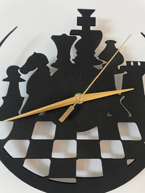 Decorative wall clock with black geometric shapes and gold hands on a white background