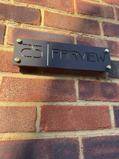 Metal house number sign on a brick wall