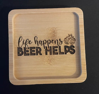 Wooden tray with 'life happens BEER HELPS' engraving on a black background