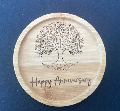 Wooden coaster with tree design and 'Happy Anniversary' text on a blue background
