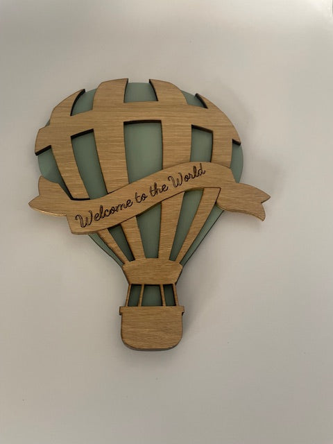 Wooden baby rattle with 'Welcome to the World' text on a white background