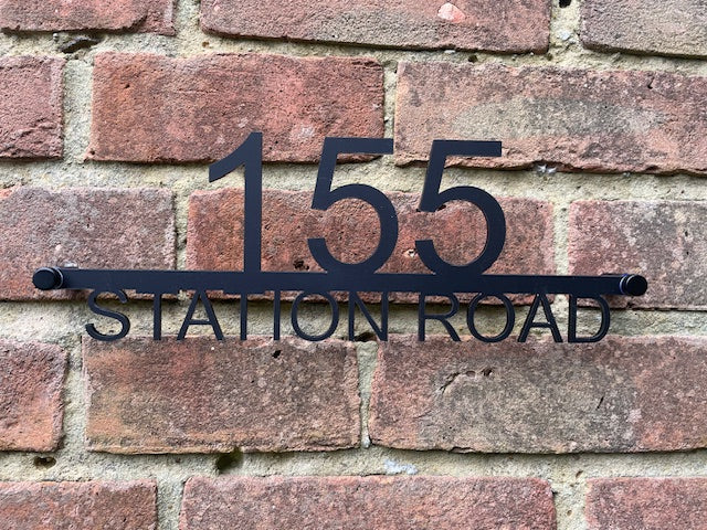House number '155 Station Road' on a brick wall