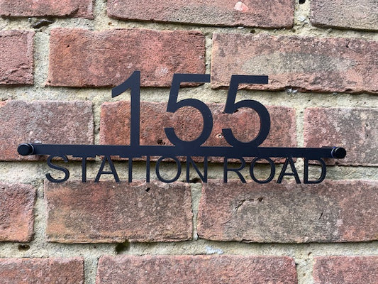 House number '155 Station Road' on a brick wall
