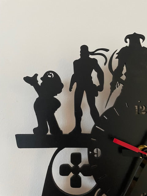 Black silhouette wall clock with detailed design on a white background