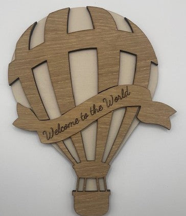 Wooden hot air balloon-shaped sign with 'Welcome to the World' text on a white background