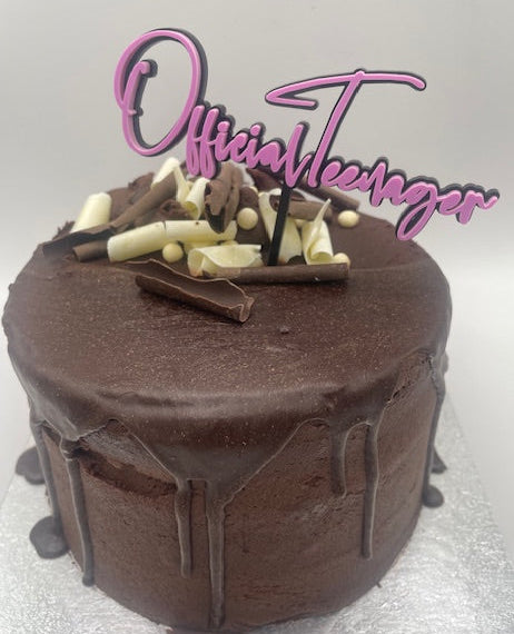 Chocolate cake with chocolate shavings on a white background, featuring the text 'Official Teenager' in pink.
