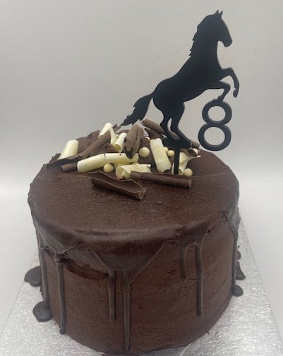 Chocolate cake with horse topper and number 8 on a white background
