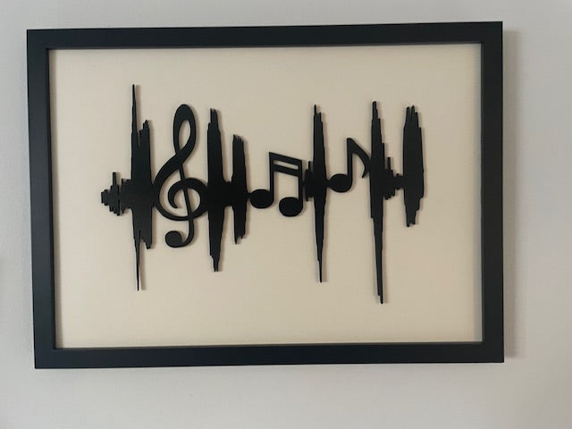 Framed artwork with black musical notes on a beige background