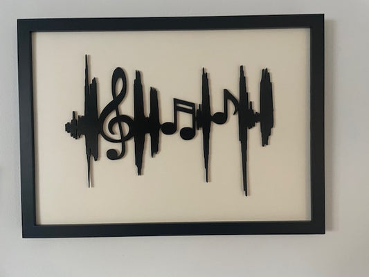 Framed artwork with black musical notes on a beige background