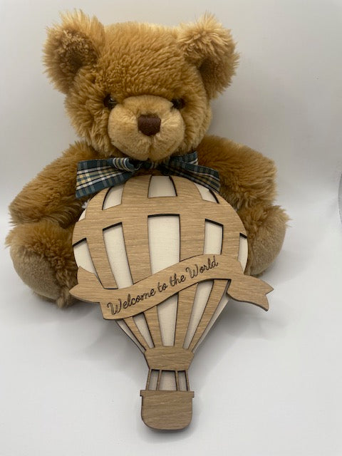 Teddy bear with a wooden airplane ornament on a white background