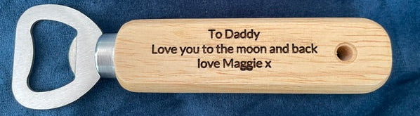Wooden bottle opener with engraved message on a blue fabric background