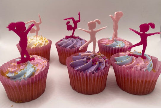 Cupcakes with dancer toppers on a white background
