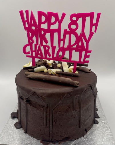 Chocolate birthday cake with pink text on a white background