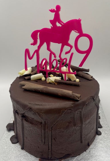 Chocolate cake with a pink 'Happy 90' decoration on a white background