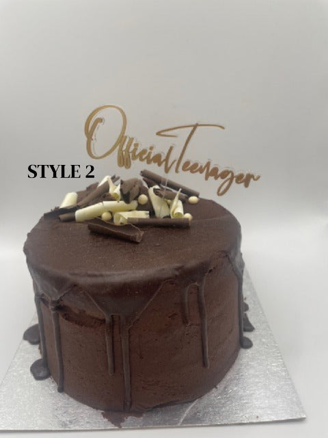 Chocolate cake with decorative elements on a silver tray, branded 'Official Teenager'.